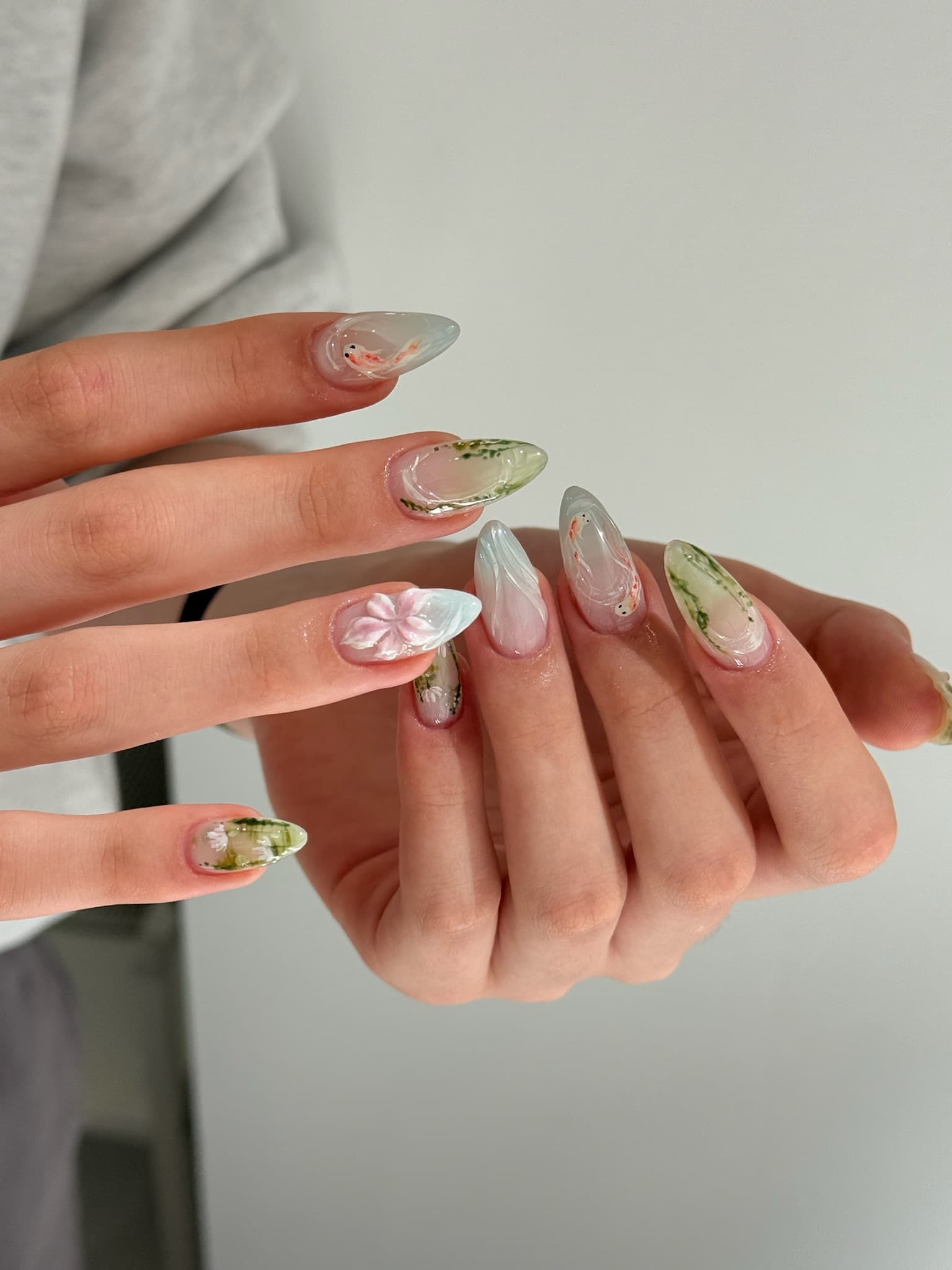 Koi pond gel nail set shown across both hands, sheer watercolor tips